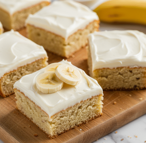Plate of moist banana bars with creamy cream cheese frosting, garnished with banana slices and walnuts, ready to serve.
